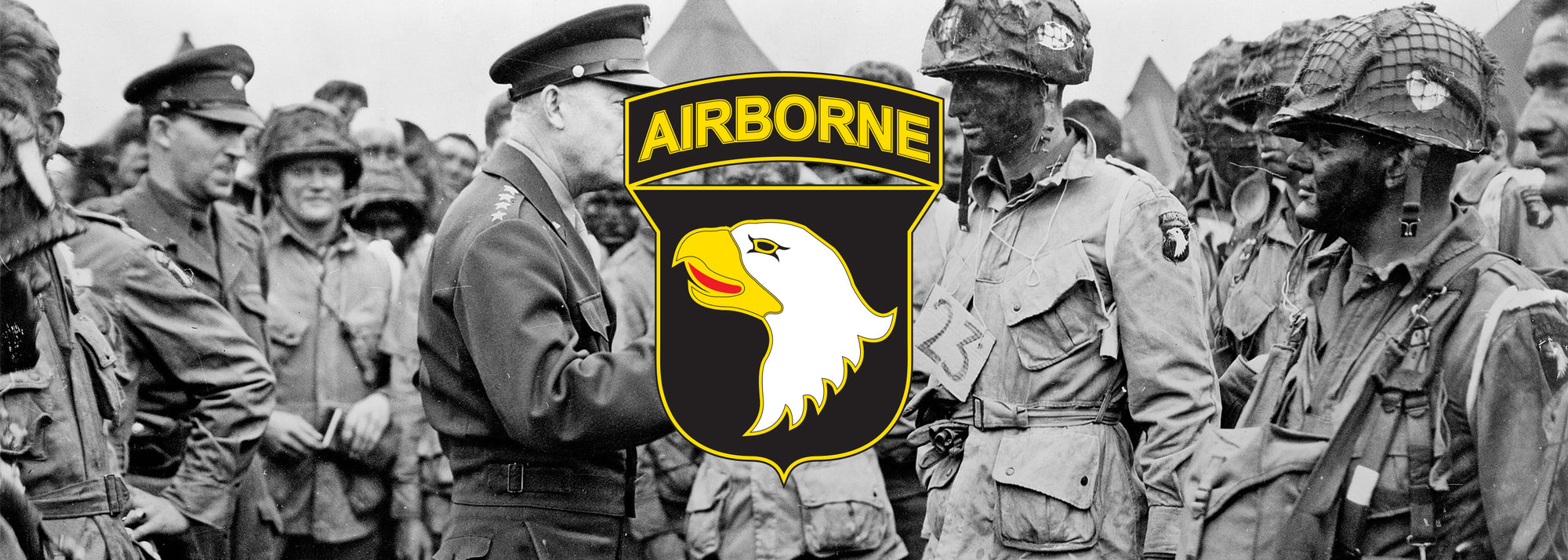 General Dwight D. Eisenhower speaking with 1st Lieutenant Wallace C. Strobel and men of Company E, 502nd Parachute Infantry Regiment on 5 June. The placard around Strobel's neck indicates he is the jumpmaster for chalk No. 23 of the 438th TCG.