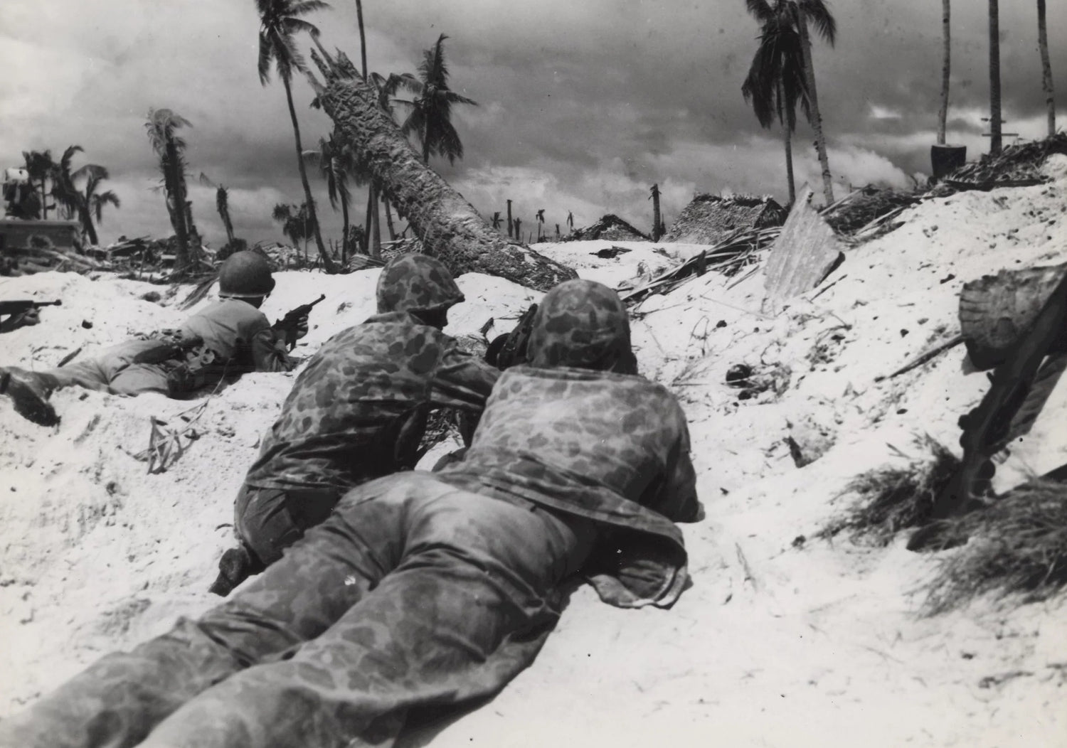 "On Tarawa Beach-Marines landing on Tarawa Island beach creep up on Jap pill boxes. The terrain of the island offered very little protective covering but these Marines made use of what little covering there was. Some of the Jap troops in pill boxes held out for two days before they surrendered or were blasted out." From the Julian C. Smith Collection (COLL/202), Marine Corps Archives & Special Collections OFFICIAL USMC PHOTOGRAPH