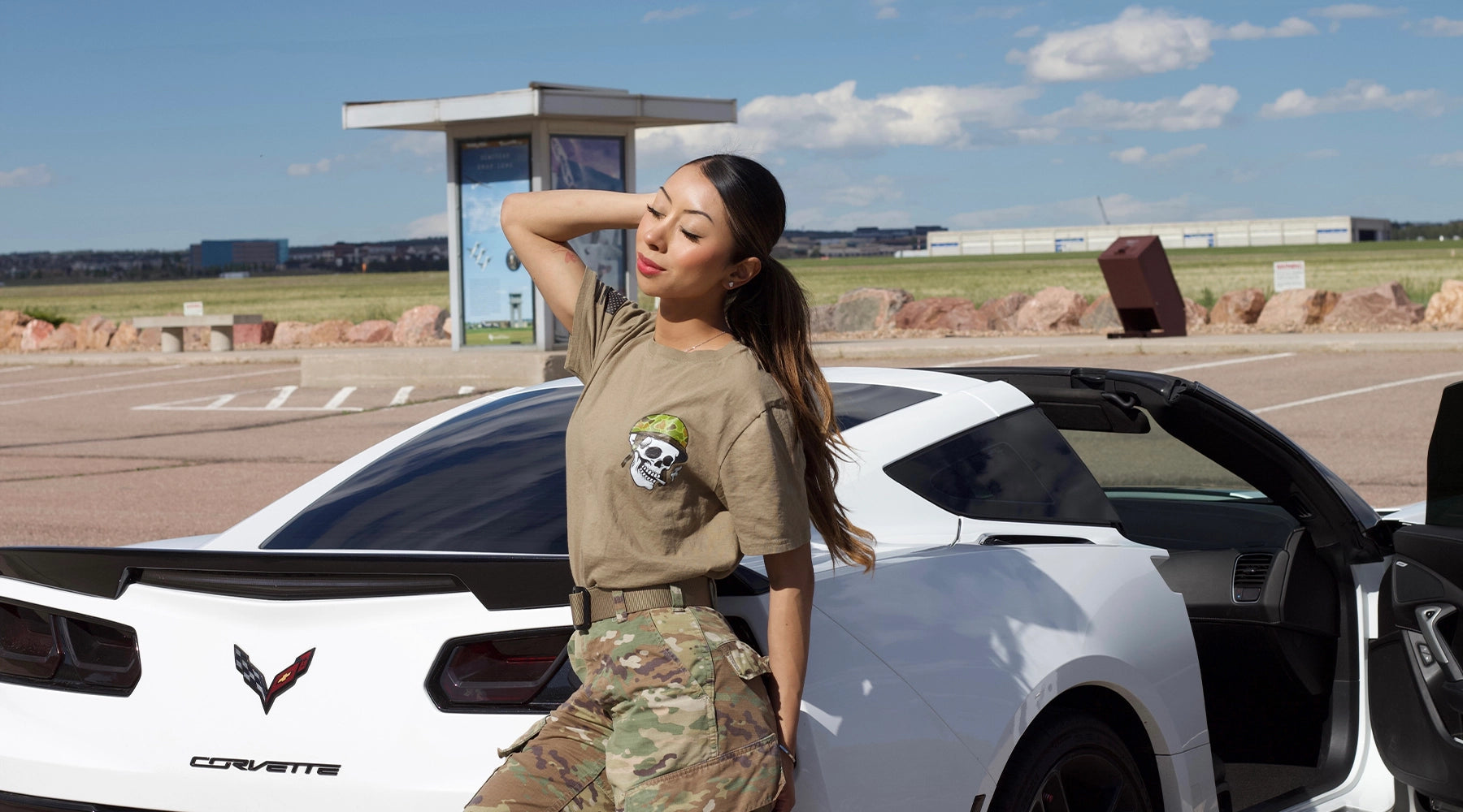 Judy Cruz, active duty U.S. Air Force, strikes a pose in front of her corvette. She is wearing her pin-up girl t-shirt from Tacticallyacquired.com